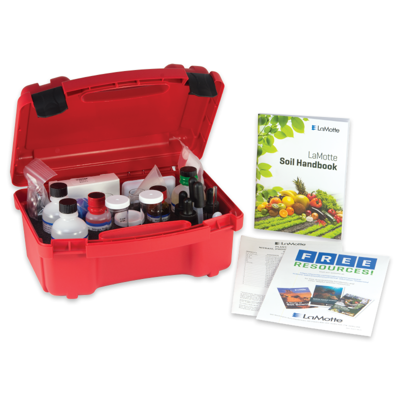 A red plastic case with Soil pH Test Kit - 5023 supplies, including bottles and droppers, sits open beside a soil handbook and informational pamphlets on a white background.