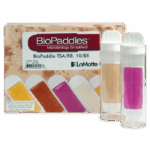 ¡Una caja etiquetada BioPaddles Microbiología Simplificada! cuenta con palas de prueba que cambian de color, junto a dos tubos transparentes con BioPaddles - Tryptic Soy & Rose Bengal Chloramphenicol Agar - 5552 —uno beige y otro rosa brillante. Marca: LaMotte.
