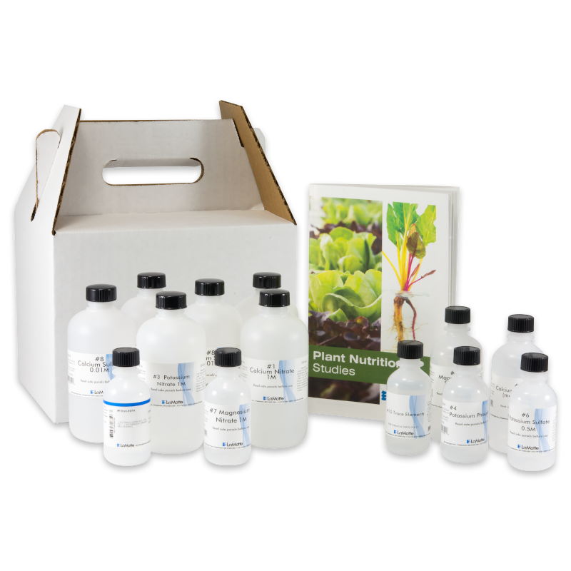 A set of plastic bottles with scientific labels is arranged next to a booklet titled Plant Nutrition Studies - 5940. A white cardboard carrying case with a handle is positioned behind the items.