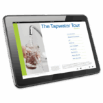 A tablet displays a webpage titled Tapwater Tour - 5972-01, featuring a list of topics and an image of a hand filling a glass with water from a kitchen faucet.