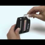 A person uses a Phosphate Test Kit - 4401-02, sliding a sample strip into the color comparator to compare its hue against reference color bars.